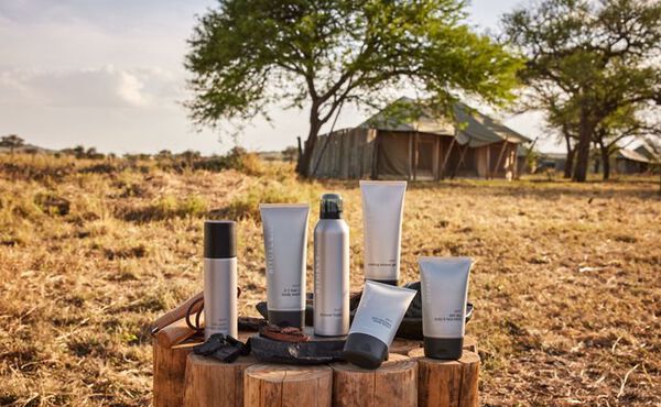 Rituals Sport collection in silver packaging, photographed in a natural setting with tents in the background.