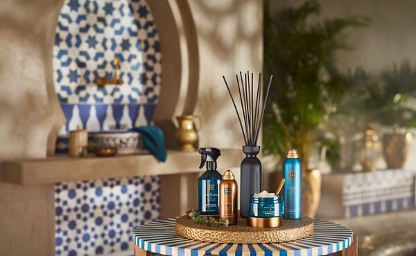 The Ritual of Hammam products with eucalyptus, displayed on a table in a Moroccan-style spa setting.
