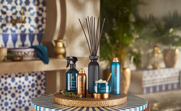 Essentiels de soin The Ritual of Hammam avec une branche d’eucalyptus, disposés sur une table dans un décor rappelant celui d’un spa marocain.