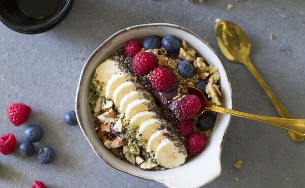 Breakfast bowl with banana, berries, nuts and seeds, a colourful and nutritious way to start the day.