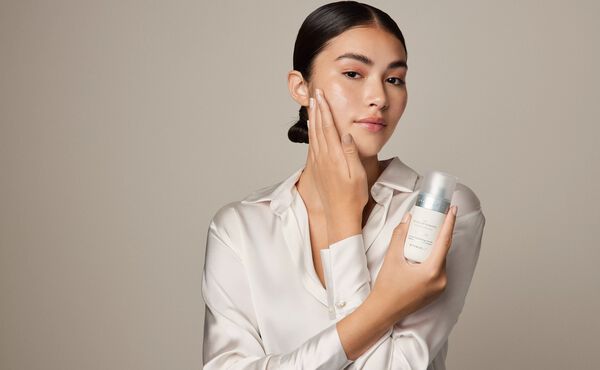 A woman gently applies The Rituals of Namaste intense hydrating serum to her face.