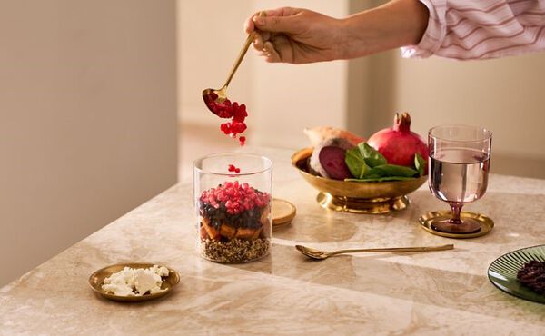 A person adding the autumn salad recipe ingredients to a mason jar for an easy batch cook lunch.