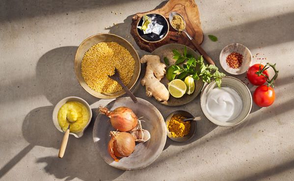 Fresh ingredients for Ayurvedic kitchari bowl recipe, including lentils, onion, ginger, coconut milk, lime and warm spices.
