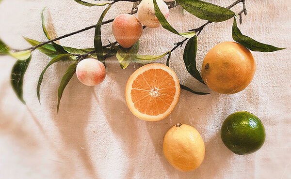 Fresh citrus fruits including oranges, lemons and limes on a linen cloth, highlighting citrus scent benefits.