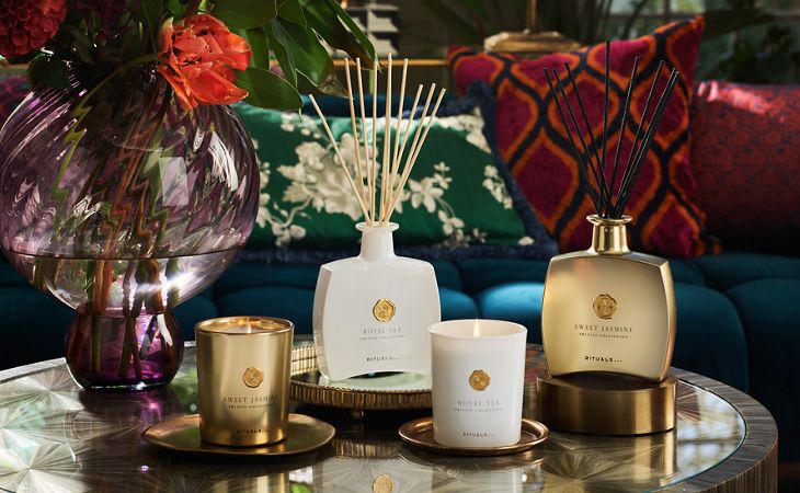 Een vaas met dieprode bloemen in warm avondlicht, gestyled om de luxe en elegantie van een hotel toe te voegen aan een interieur.