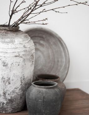 Minimalistiska keramikvaser med rustik textur och nakna kvistar i typisk japansk wabi-sabi-stil.