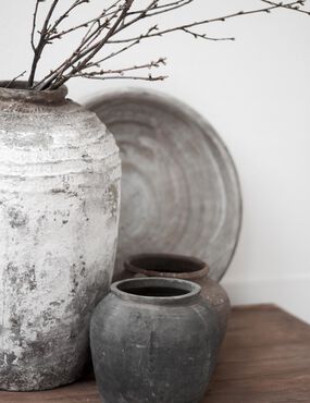 Minimalist ceramic vases with rustic textures and bare branches, in the style of Japanese wabi-sabi aesthetics.