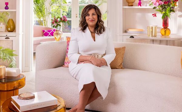 Purpose coach Ani Naqvi seated in a bright, stylish living room, sharing guidance on how to find your purpose.