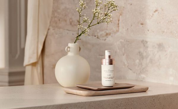 The Ritual of Namaste face serum displayed in a serene bathroom.