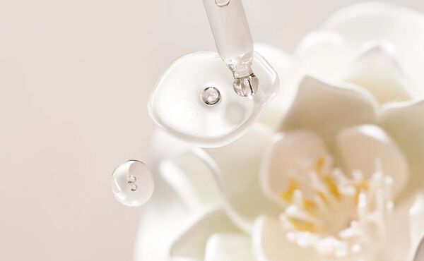 A dropper with hyaluronic acid serum and holy lotus extract, highlighting hydrating skincare ingredients.