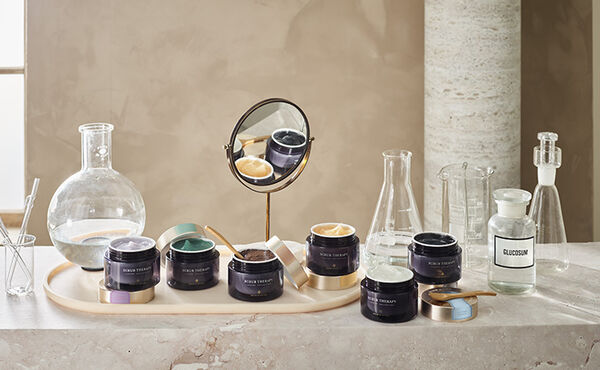 A selection of Rituals body scrubs lined up on a marble bathroom counter.