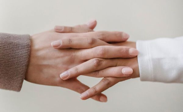 Two hands gently touching to symbolise emotional connection and different forms of love.