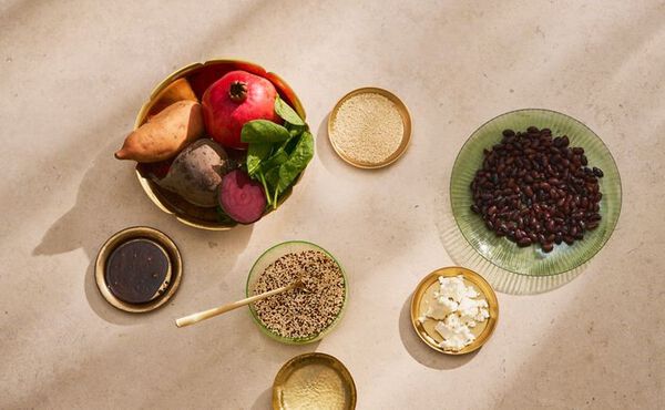 Ingredients for the autumn salad recipe laid out in bowls, including sweet potato, quinoa, olive oil, black beans and feta.