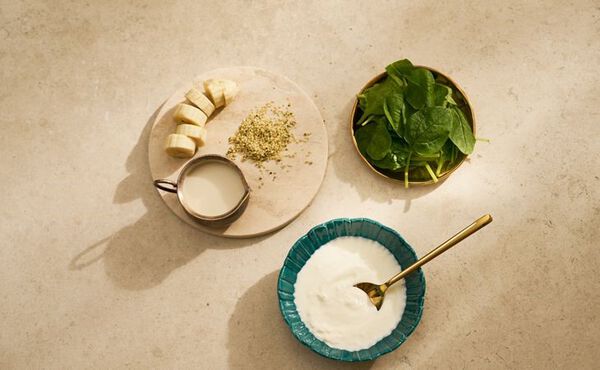 Banana slices, spinach, and yogurt ready to make a protein-rich breakfast bowl.