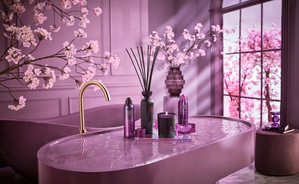Home fragrance and bodycare products from The Ritual of Yozakura, shown in a glamorous purple bathroom inspired by hanami.