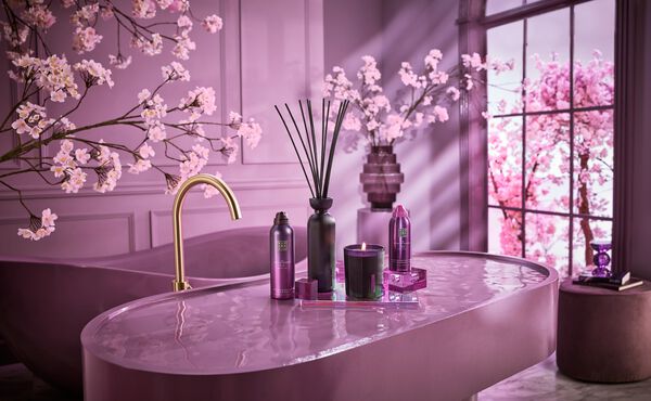 Profumo per la casa e prodotti per la cura del corpo di The Ritual of Yozakura, esposti in un bagno elegante dalle tonalità viola, ispirato all’hanami.