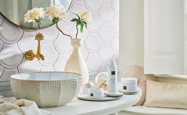 The Ritual of Sakura collection displayed in a light, floral bathroom setting, with delicate white packaging symbolising renewal.